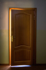 a wooden door with bright sunlight peeking through. the concept of a new life and new opportunities