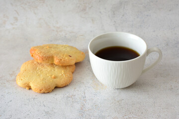 a cup of coffee with sugar cookies next to it 