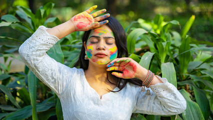 Woman celebrating Holi festival with powder colours or gulal, Holi celebration outdoor