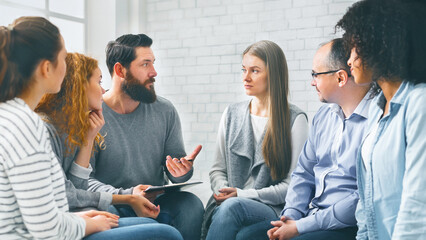 Therapist consulting patients of rehab group at therapy session