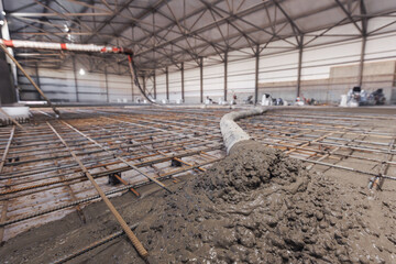 Concrete concreting floors of buildings in construction site. Concept pouring cement to iron...