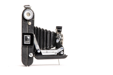 Side view of an old bellows film camera with the lens open isolated on white