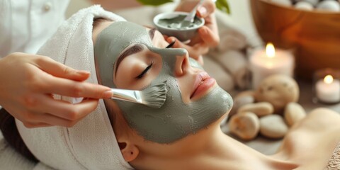 portrait of a beautiful girl with a clay mask on her face, professional cosmetology procedure, applying a green clay mask, spa and self-care concept
