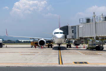 A busy airport tarmac runway with various commercial aircraft planes parked near the terminals.