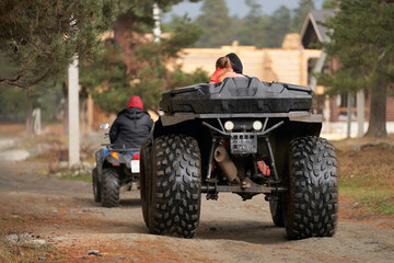 A group of tourists on all-terrain vehicles returning to a campsite in the mountains.