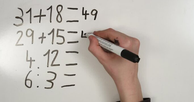 Hand writing mathematic examples on whiteboard. 4K stop motion animation.