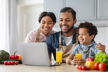Happy black family watching food blog together