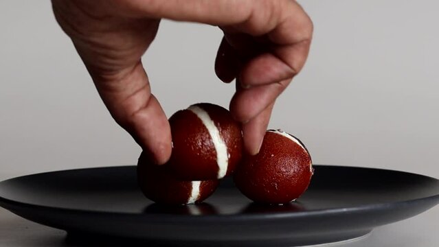 Serving Malai Gulab Jamun. Gulab Jamun sandwich with milk cream filling.