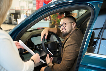 Guy talks to the seller from inside the car