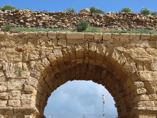 Ancient Roman aqueduct in Caesarea against the blue sky. Traveling around Israel.