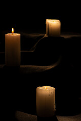 Candles, beautiful candles positioned on dark surface, black background, selective focus.