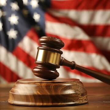 enforcing rights and law with a judge's gavel against the backdrop of an American flag