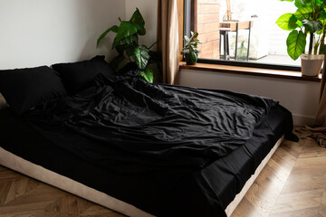 set of black bed linen on the bed in the bedroom daylight - 766569960
