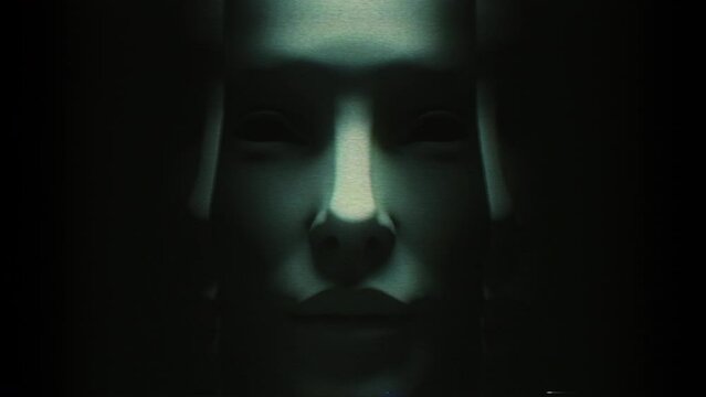 Close in on a darkly lit human face split down the middle and opening on a loop to reveal repeated faces inside each other.