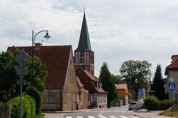 Town Street. Tower of Church of the Resurrection of the Lord (kosciol Zmartwychwstania Panskiego) in background. Drawsko Pomorskie, Poland. - obrazy, fototapety, plakaty