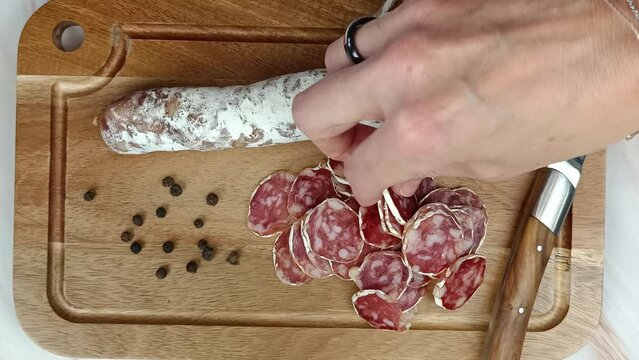 plusieurs personnes mangeant des tranches de saucisson sec