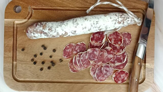 personne gourmande voulant manger des tranches de saucisson
