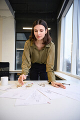 Woman clothing designer sketching new collection in her office