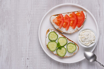 Healthy sandwiches with white cottage cheese, cucumber and tomato, with copy space for text