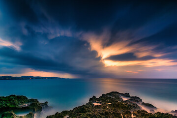 Dusk falls before the storm over a tropical rocky beach in Jamaica - Long Exposure