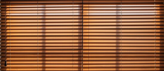 An up-close view of a window featuring a wooden blind covering it, adding a touch of warmth and texture to the room