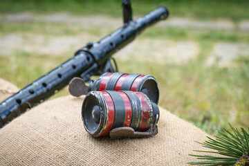 Fototapeta premium WWII machine gun and two black red hand grenades on sandbags