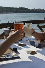 brindisi tra amici con cocktail colorati in un bar all'aperto in riva al mare