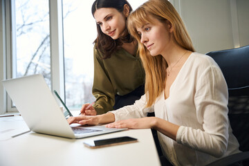 Clothing designer and assistant working together using technologies