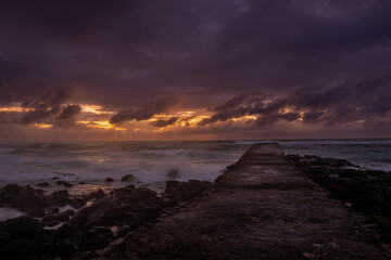 Long exposure view of sunrise from a pier at La Cambuse beach which is located in the south of...