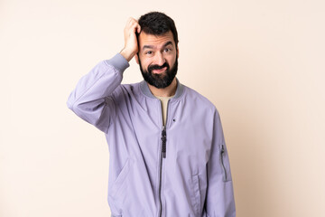 Caucasian man with beard wearing a jacket over isolated background with an expression of frustration and not understanding
