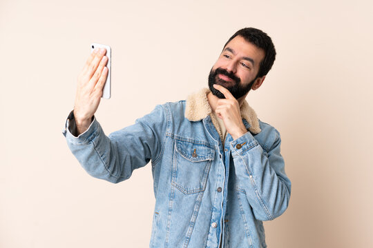 Caucasian man with beard over isolated background making a selfie