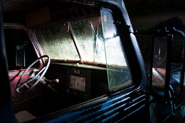 Inside old car with headlights shining.