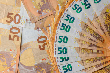 Fifty euro banknotes, arranged in a fan, against money background