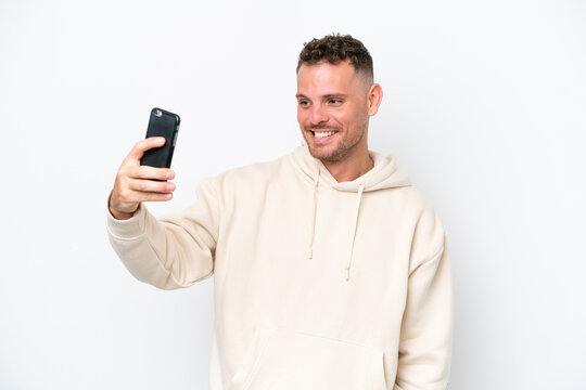 Young caucasian handsome man isolated on white background making a selfie