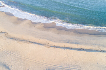 overhead aerial view of a turquoise water beach at sunrise, drone view photography