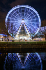 Ferris wheel at night, reflected on water