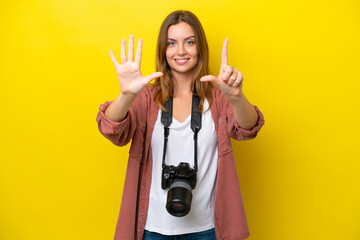 Young photographer caucasian woman isolated on yellow background counting seven with fingers