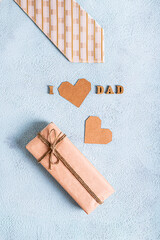 Father's day craft gift, tie, heart and inscription on a blue background vertical view