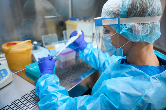 Female infectious disease specialist working in laboratory with biomaterial