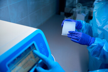 Laboratory assistants work on machine for automatic isolation of nucleic acids