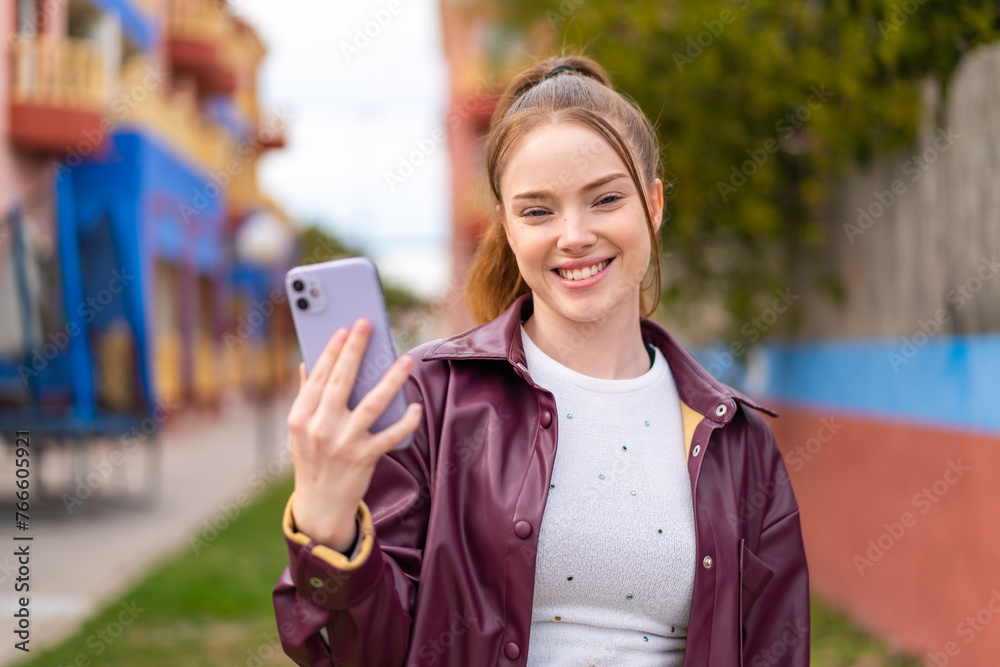 Poster Young pretty girl using mobile phone at outdoors smiling a lot