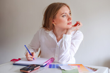  girl designer works in the office at her desk