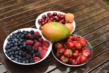 Seasonal fruits and berries. Mango, strawberry, raspberry, blueberry.