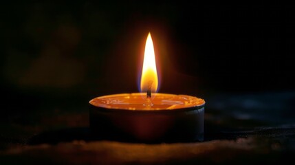 Illuminated Candle in Dark Setting