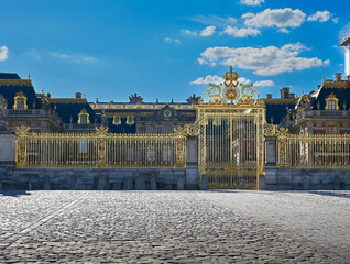Versailles, Paris, France, June 30, 2022. The magnificent golden gate of the royal palace. The late afternoon light enhances its brilliance. Nobody.
