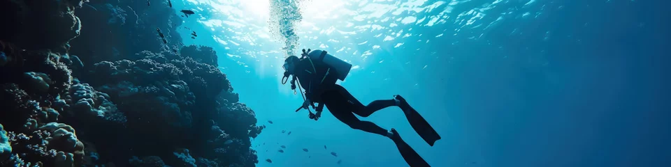 Badkamer foto achterwand A person diving into the water near a vibrant coral reef, exploring the underwater world © sommersby