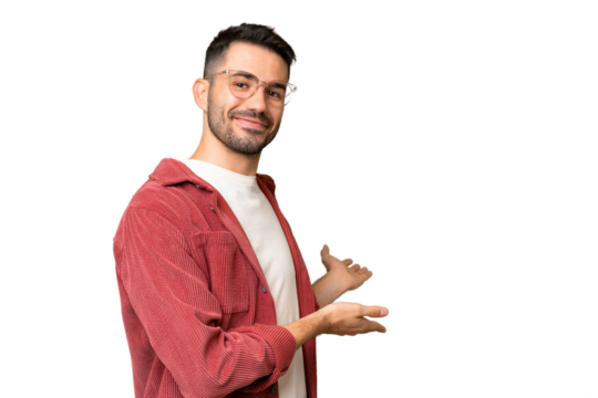 Young handsome caucasian man over isolated chroma key background extending hands to the side for inviting to come