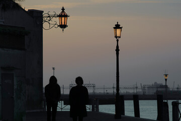 Couple at sunset on the ambankment in Venice