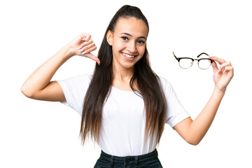 Young Arabian woman holding glasses over isolated chroma key background proud and self-satisfied