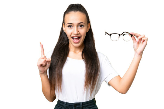 Young Arabian woman holding glasses over isolated chroma key background pointing up a great idea